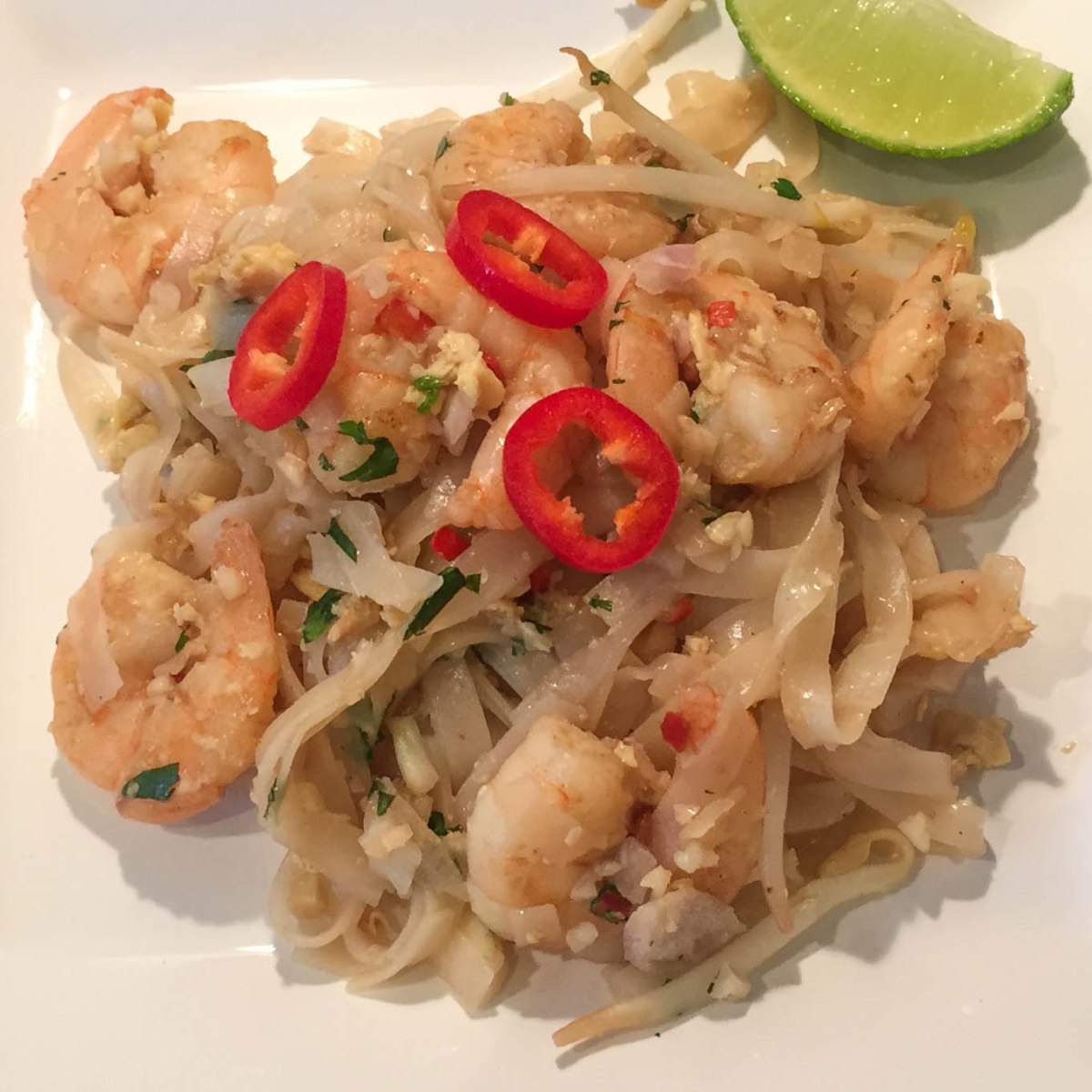 A photo of the finished Pad Thai dish served on a white plate and ready to eat