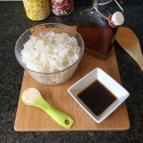 A photo of some of the ingredients: cooked rice noodles, fish sauce, tamarind water and light brown sugar