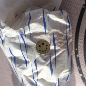 A photo of a smiley face sticker on the burger packaging from GoGo Gogi Gui.
