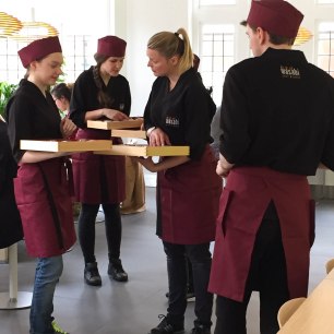 A photograph of some of the Wasabi staff in burgundy and black uniform.