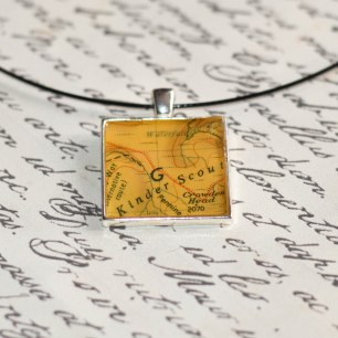 A photograph of the Kinder Scout pendant placed on top of a handwritten letter