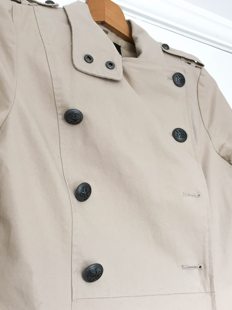 A close-up photograph of Emma's coat before the old buttons were replaced