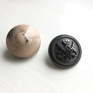 A photograph of a new and old button for comparison