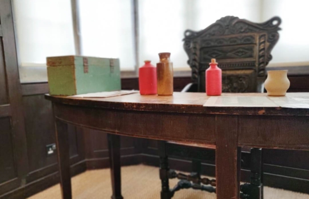 Wooden desk with a box and bottles on top